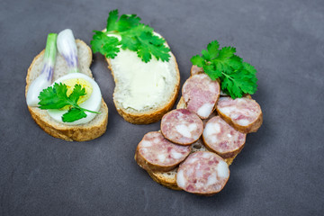 Snacks, bread with sausage and butter, onion, parsley, egg