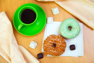 Sweet donuts and cup of black coffee, morning light breakfast