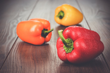 sweet peppers on the brown wooden table