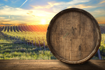 Red wine with barrel on vineyard in green Tuscany, Italy