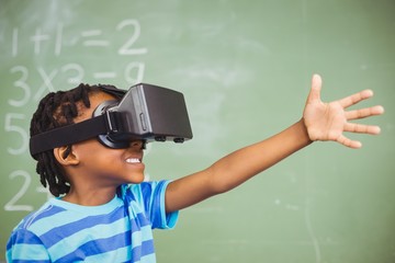 School boy in virtual reality glasses in classroom