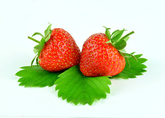 Two strawberry with leaves isolated on white background.