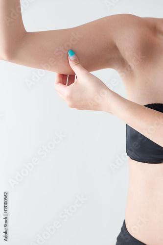 二の腕を摘む女性 白バック Wall Mural Wallpaper Murals Hanack