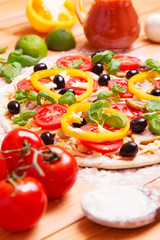Prepared Italian pizza with tomato, pepper, cheese and other ingredients other on the wooden background 