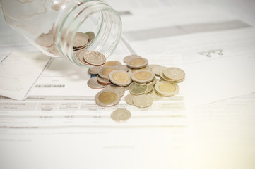 Close up of glass bottle stacking silver coins on paper bill