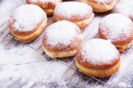 German donuts - berliner with icing sugar on a dark wooden table