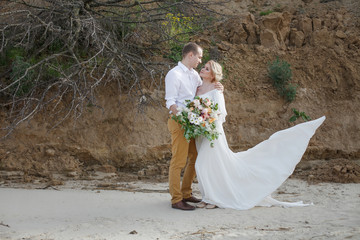 young couple; bride; groom; at the sand shore; married couple; s