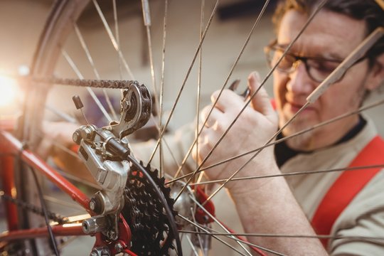 Mechanic repairing bike in workshop