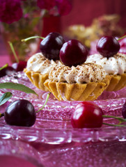 Cupcakes (three cakes) with cherries and whipped cream