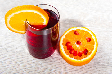 Pomegranate juice in a glass and orange slices
