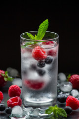 Mineral water with berries and ice cubes.