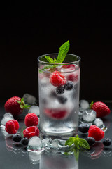 Mineral water with berries and ice cubes.