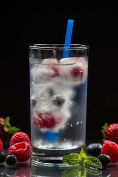 Mineral water with berries and ice cubes.