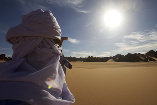 A Tuareg walking on a dune of the erg of Uan Kaza in the Fezzan desert, Libya