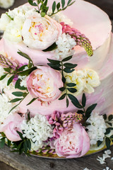 Big pink wedding cake decorated by natural flowers