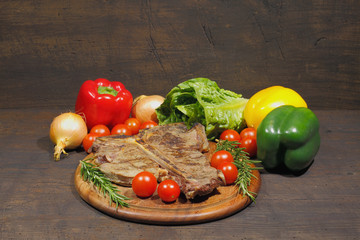 Grilled T bone steak with rosemary tomatoes, paprika onions and