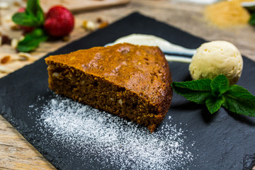 A beautiful slice of chocolate cake on the black Board with ice cream