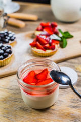 Beautiful strawberry dessert in a jar on light Board