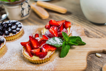 Cake with strawberries and whipped cream decorated with mint leaves