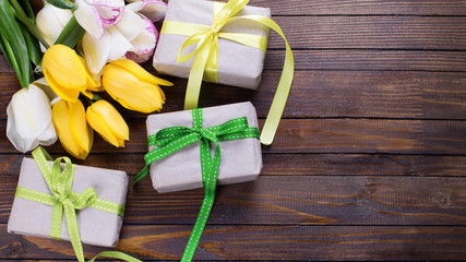 Bright yellow and white spring tulips and boxes with presents on