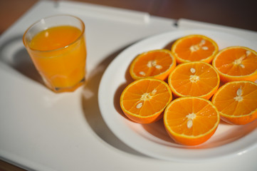 Top view on slices of orange on white plate background, closeup flat lay