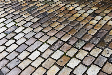 Wet cobblestone street, ideal for backgrounds and textures.