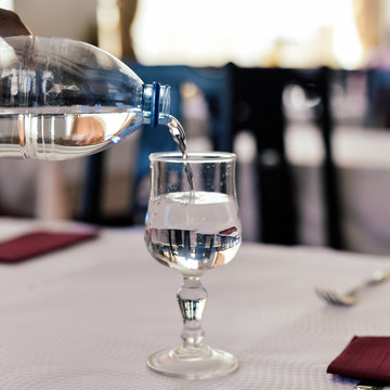 Closeup On Pouring Mineral Water In The Glass, Restaurant Background