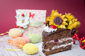Picture close up on set of cake, colorful eggs and gift decorations