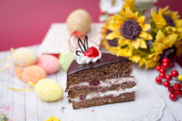Picture close up on set of cake, colorful eggs and gift decorations