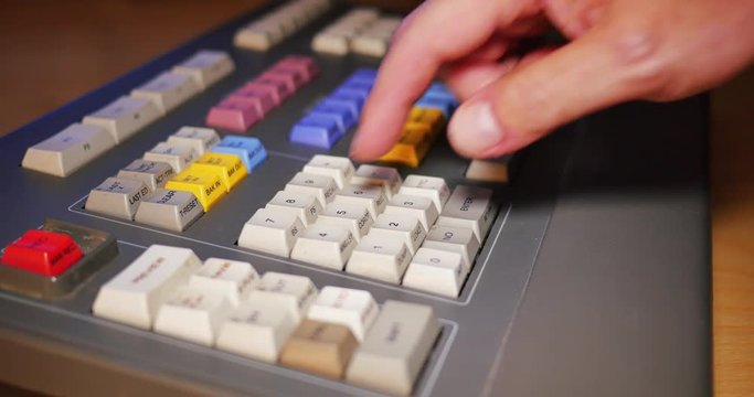 A closeup shot of a person using an edit controller to assemble video in a linear tape-based edit workstation.