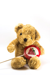 Teddy bear hold red strawberry  Lollipops isolated on white