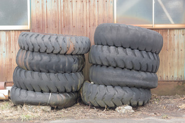 Obraz premium pile of old tires and wheels for rubber recycling in countryside