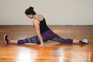 Athlete young woman doing exercise at gym. Indoors.