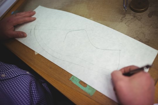 Cobbler making a shoe sketch on paper
