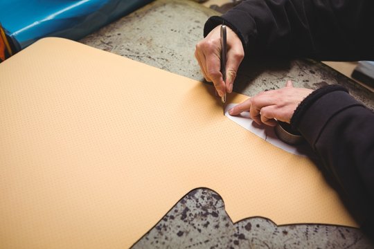 Cobbler cutting a design from material 