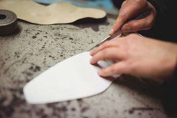 Cobbler cutting a piece of material 