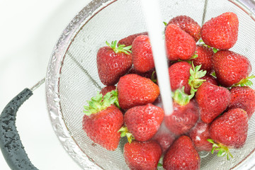 Washing strawberries in a round mesh strainer
