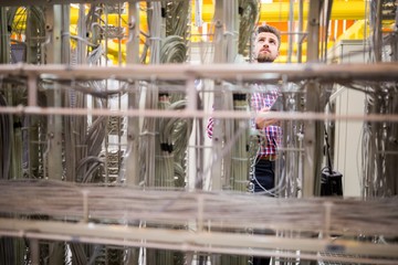 Technician using digital tablet while analyzing server