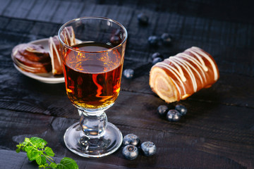 Tea cup, slices of Swiss roll and blueberry