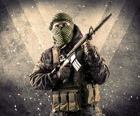 Portrait of a dangerous masked armed soldier with grungy backgro