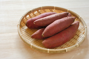 ザルに入った薩摩芋　木目背景


