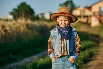 Little boy dressed in Western style in the field