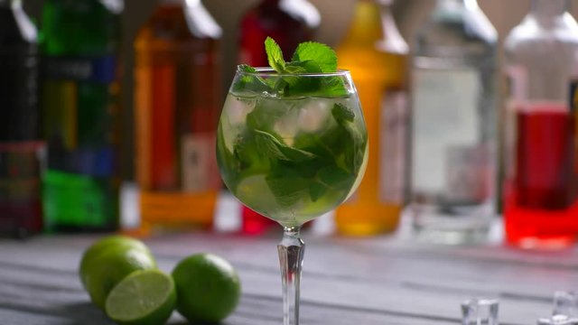 Mint branch and green cocktail. Hand puts mint into beverage. Fresh mint and citrus fruit. Special recipe of hugo cocktail.