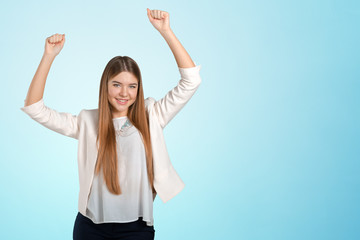 Young happy businesswoman with arms up