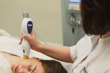 Woman doing cosmetic procedures in spa clinic.