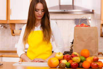 Obraz na płótnie Canvas Woman housewife in kitchen with many fruits