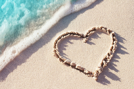 Love word handwritten on a tropical beach