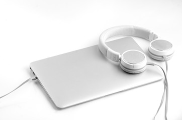 Silver laptop notebook and silveron-ear headphones isolated on w