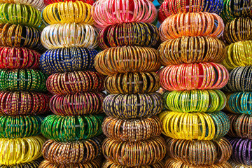 Colourful Indian wrist bracelets stacked in piles on display at a shop in Jaisalmer, India.