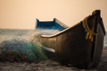 Fisherman boat with fishing nets on the Gokarna beach near the ocean in Karnataka, India